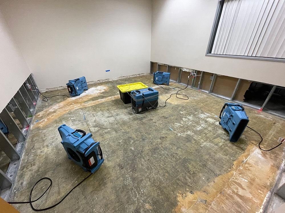拆除受损地面与墙板后在混凝土地面布置风机与除湿机进行结构烘干